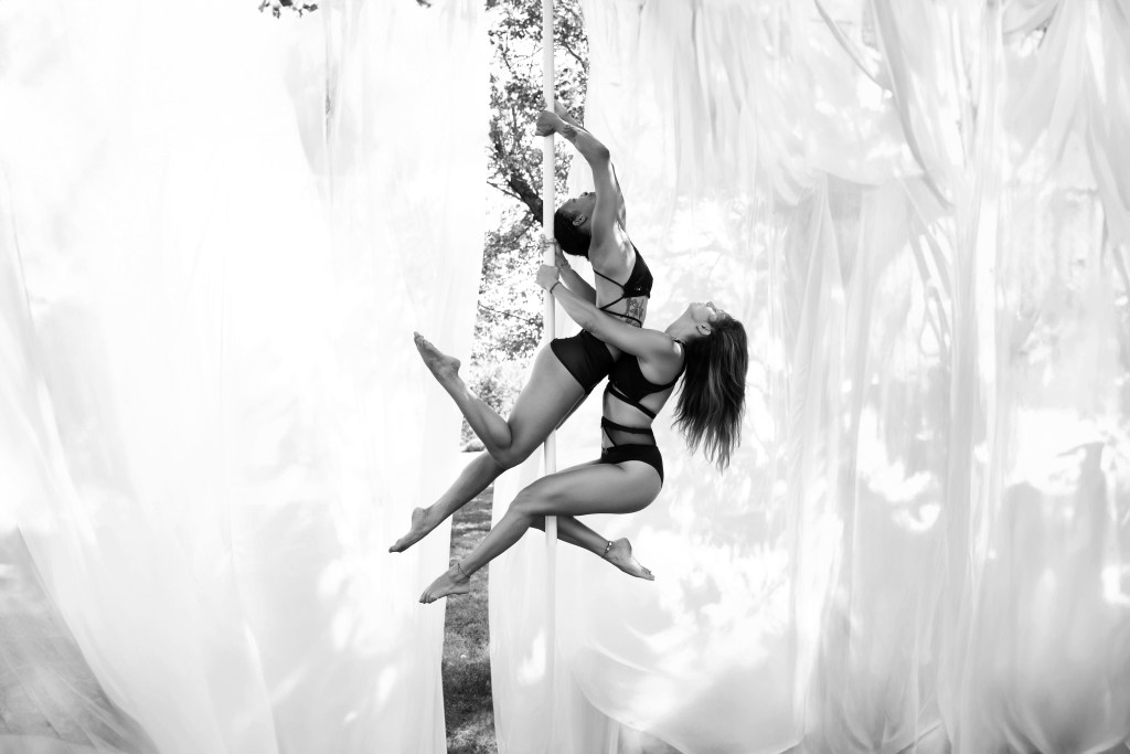 Photo d’une séance en extérieur avec le Studio Solair, où les élèves pratiquent la pole dance, la souplesse ou le renforcement musculaire sur des podiums, au cœur de la nature, dans un cadre inspirant et ensoleillé
